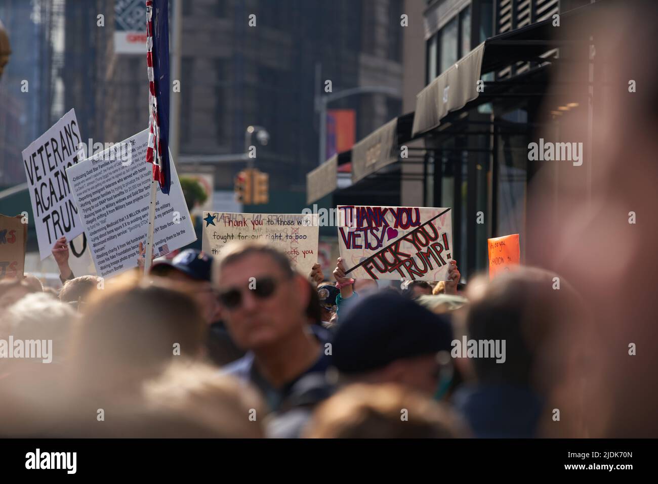 Manhattan, New York,USA - November 11. 2019: Trump protesters during Veterans day in NYC, Signs above peoples heads. Stock Photo