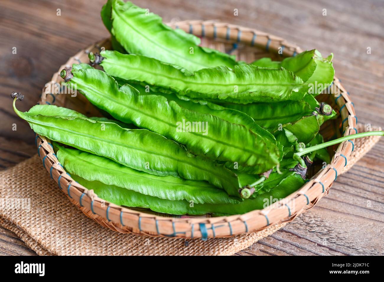 Winged Bean on basket and sack background, Psophocarpus tetragonolobus - Green winged or Four angle beans Stock Photo
