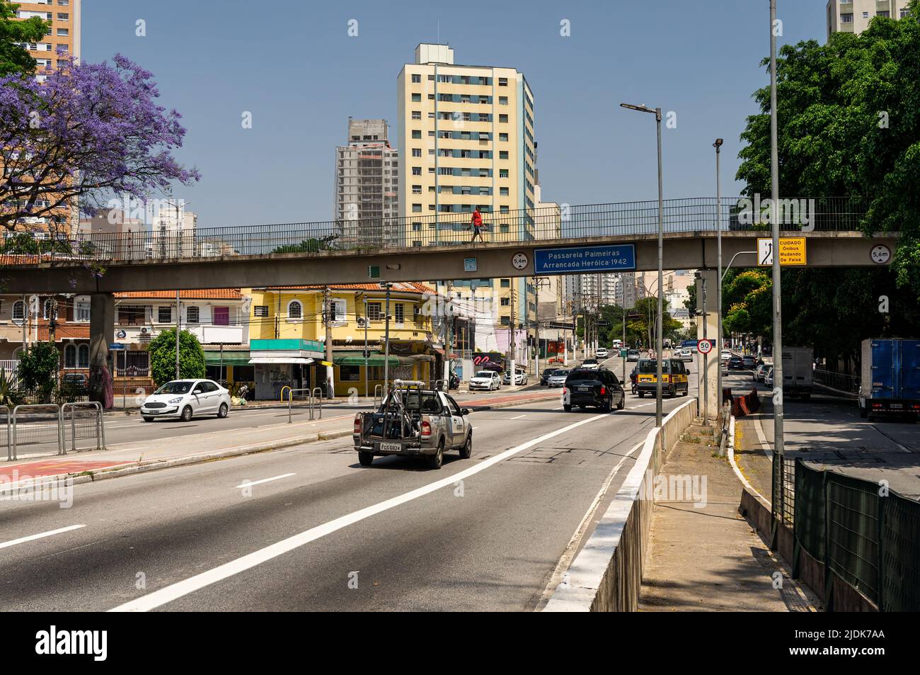 Normal business day traffic passing by Antartica avenue and Palmeiras Arrancada Historica 1942 footbridge under clear blue sky in Agua Branca district Stock Photo
