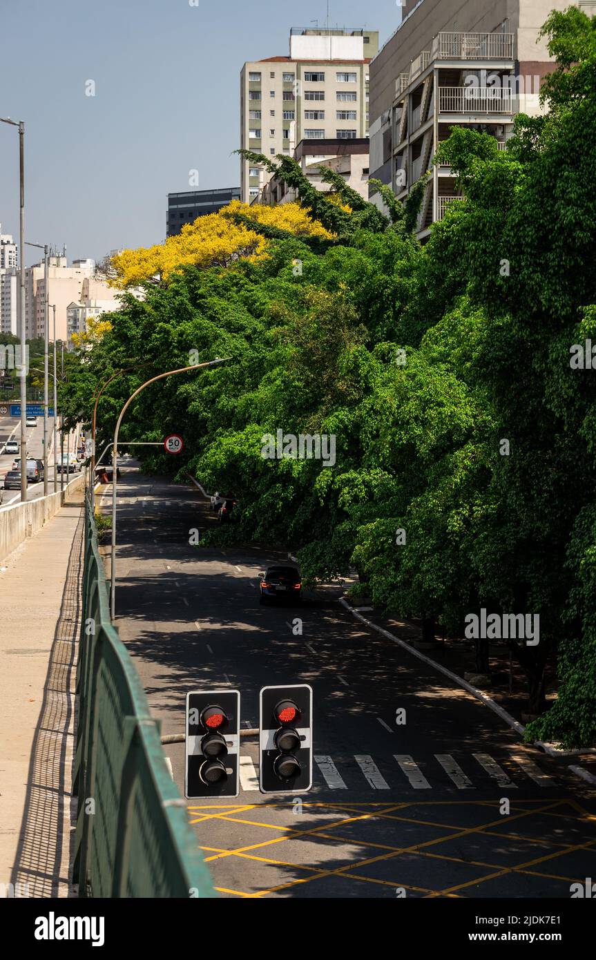 View of Sousa Aranha square access road, close to West Plaza shopping mall, covered by tree shade right at Antartica viaduct under a sunny blue sky. Stock Photo