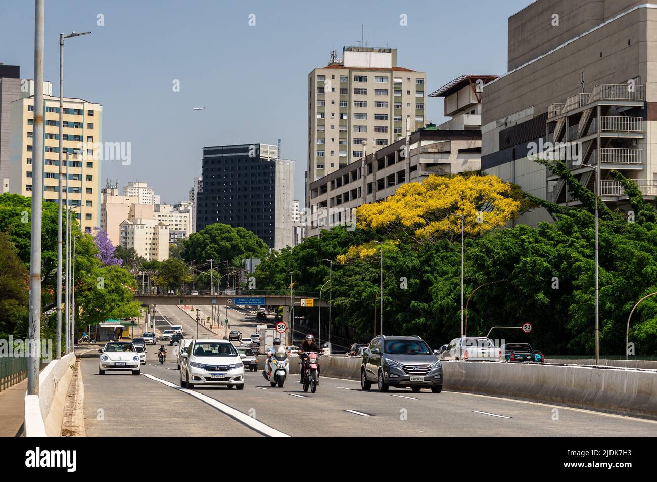 Oncoming traffic passing over Antartica viaduct, right at West Plaza shopping mall in Agua Branca district under sunny clear blue sky in business day. Stock Photo