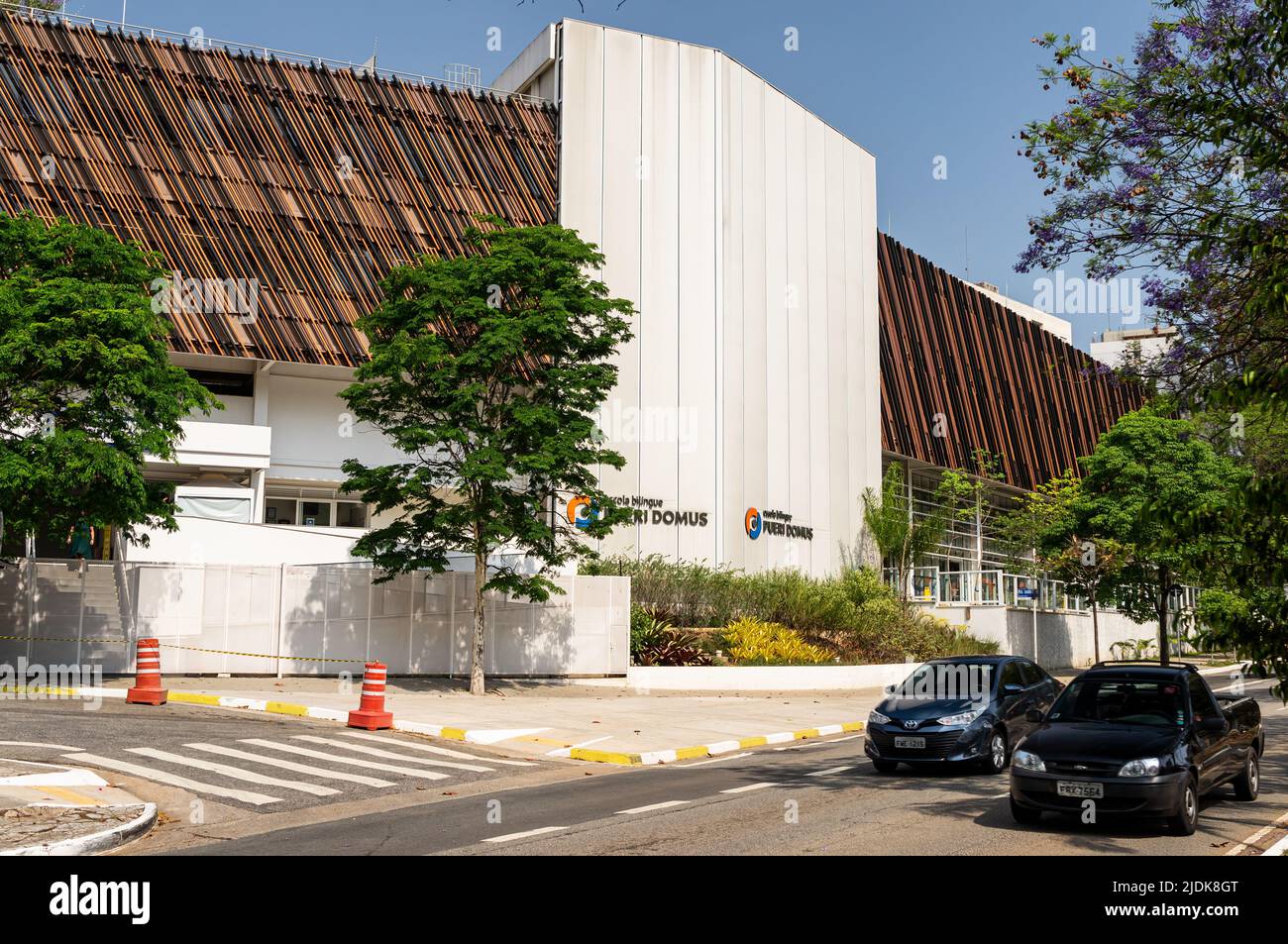 Facade of Pueri Domus bilingual school building located at the corner of Ministro Godoi street with Sumare avenue under sunny clear blue sky. Stock Photo