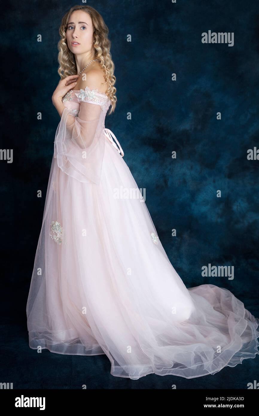 A fairytale princess with blonde hair wearing a pink gown Stock Photo