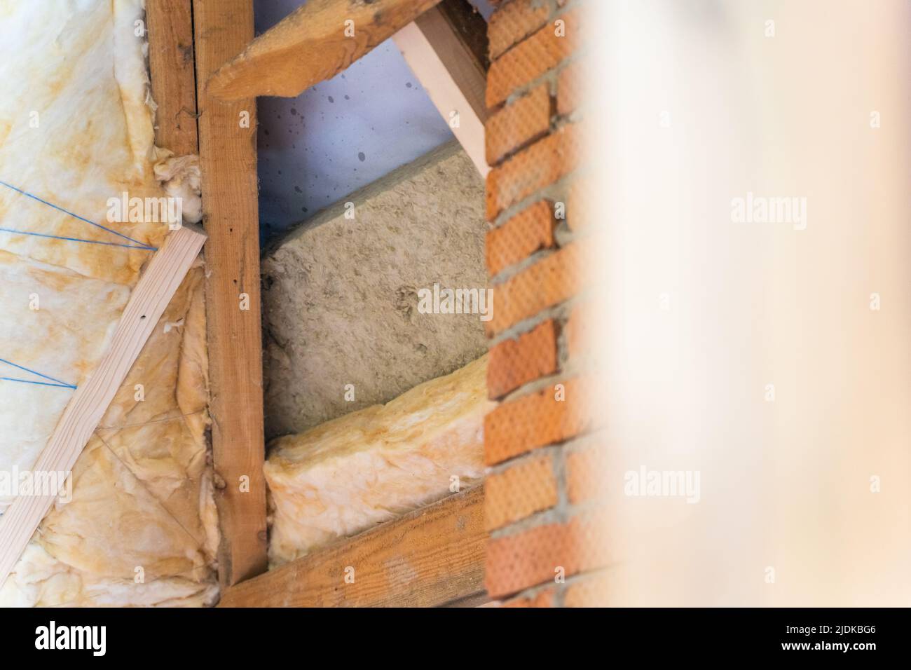 Laying sheet insulation in two layers between the roof rafters. Alternate insulation with