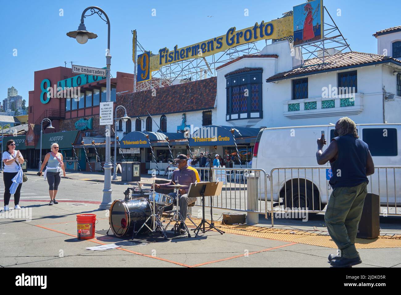 A black man on drums plays music near Fisherman's Grotto at Pier 45 in San Francisco, California. Stock Photo