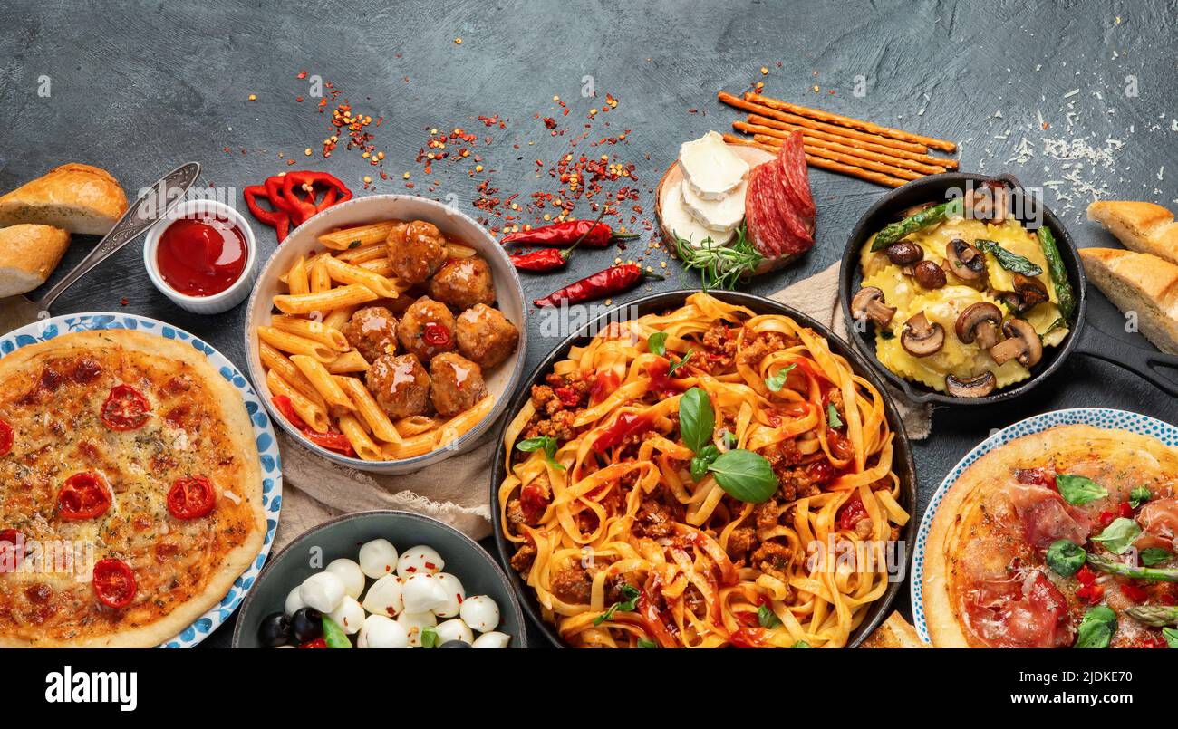 Italian food assortment on dark background. Traditional food concept. Dishes and appetizers of indeed cuisine. Flat lay, top view, copy space Stock Photo
