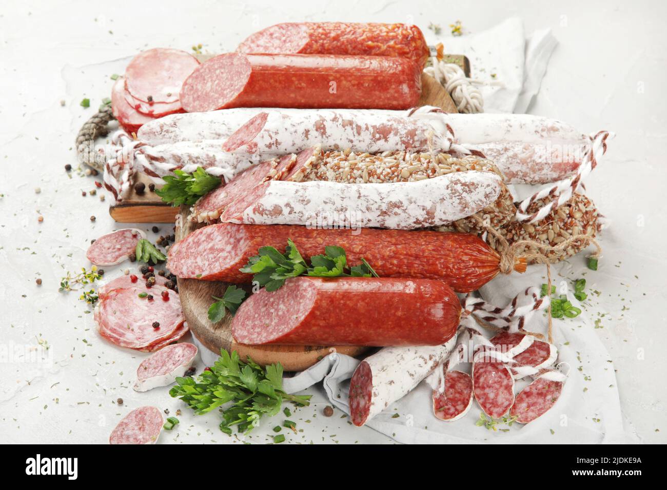 Sausages salami assortment on light background. Meat product made of finely chopped and seasoned meat. Flat lay, top view Stock Photo