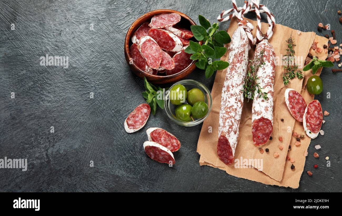 Traditional Spanish fuet on gray background. Dry cured pork sausages with peculiar taste. Flat lay, top view, copy space Stock Photo