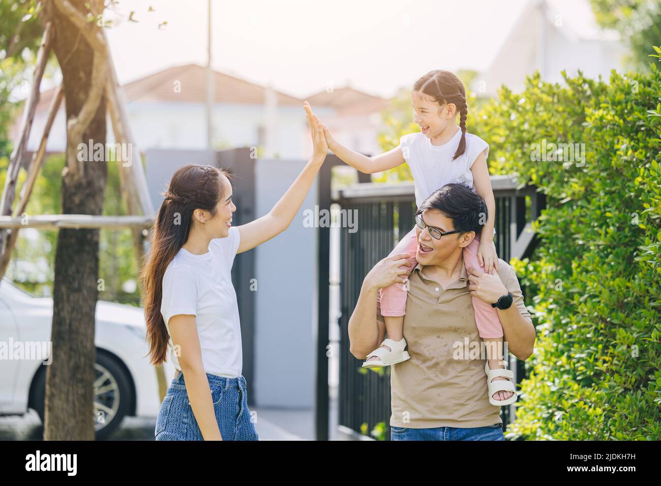 happy young Asian family playing together at home outdoors parent with one child leisure lifestyle. Stock Photo