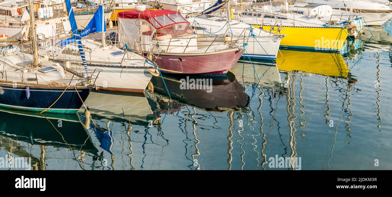 Hulls of sailboats and their reflection in the port of Sete, in Occitanie, France Stock Photo