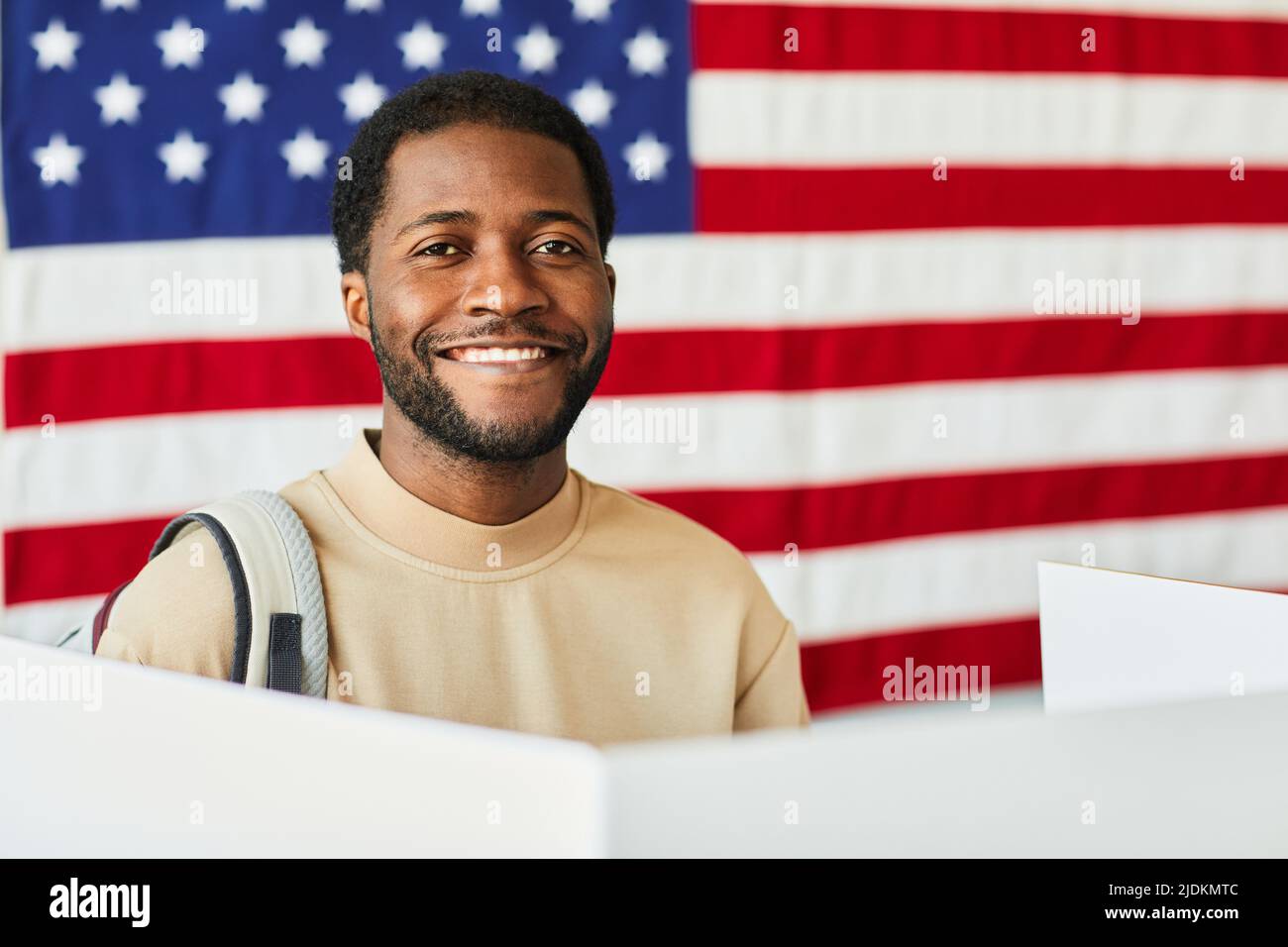 Portrait of smiling black man voting against USA banner background ...