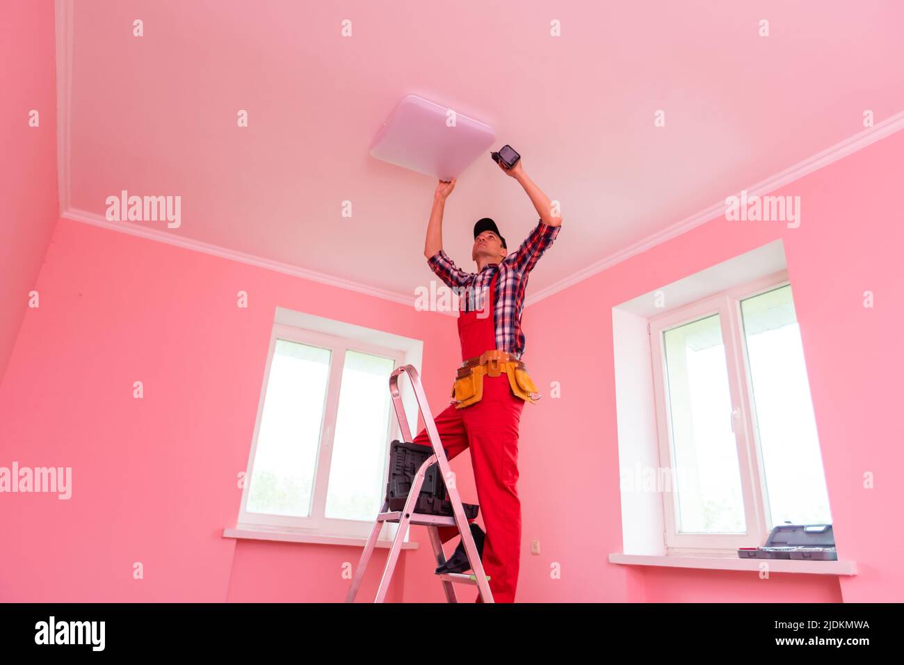 Portrait Of A Male Electrician Fixing Light On Ceiling Stock Photo - Alamy