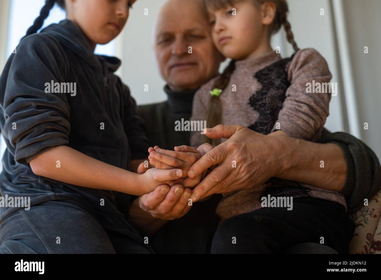 Hands of the old man and a child's hand. Stock Photo