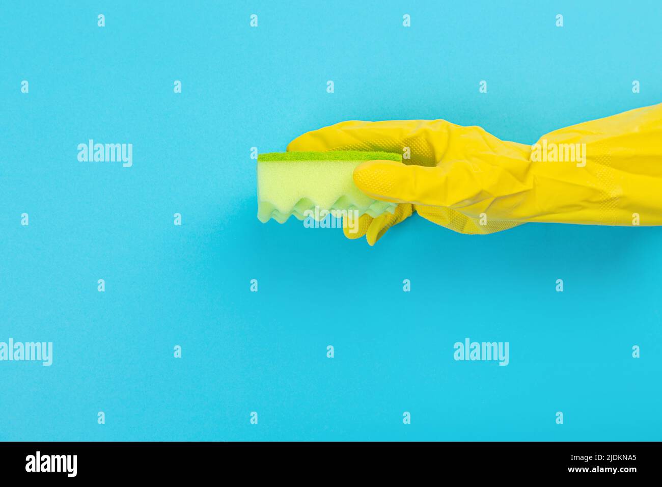 worker's hand in yellow rubber protective glove with micro fiber green ...