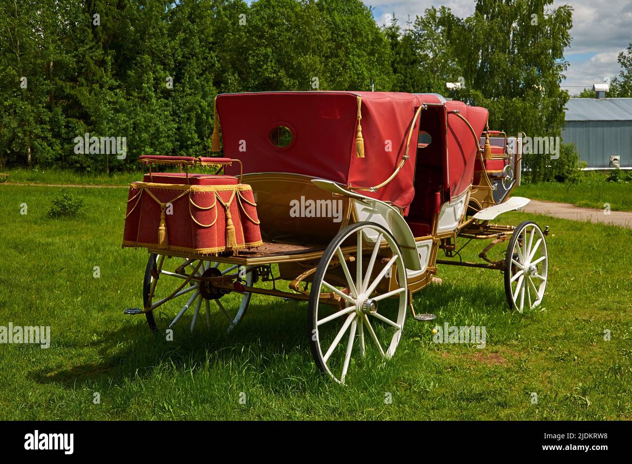 A vintage carriage is standing on the lawn. Without horses Stock Photo
