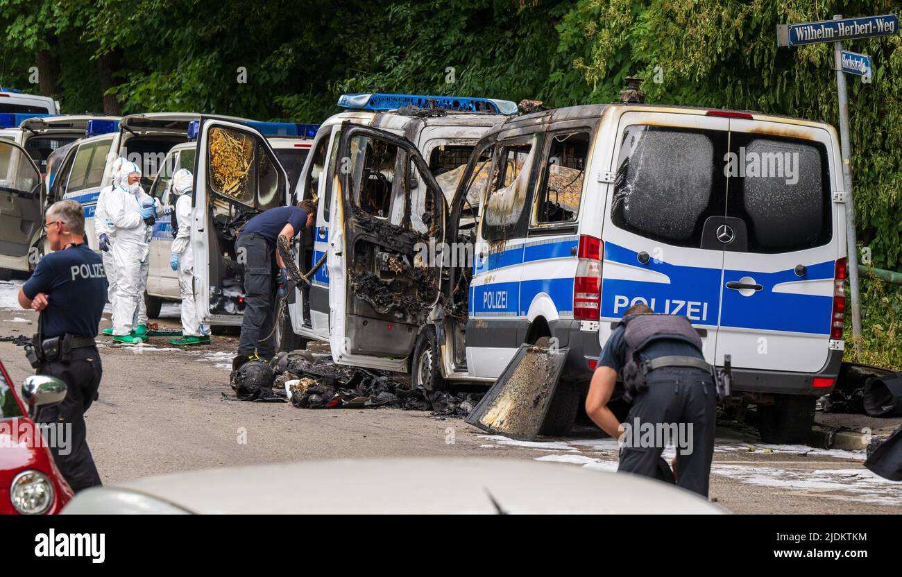 Munich, Germany. 22nd June, 2022. Forensics investigators work on police cars that burned out during the night. The team buses of the federal riot police are parked in front of a hotel where police officers are accommodated for the G7 summit. Investigators assume that the fire was caused by arson. Credit: Peter Kneffel/dpa/Alamy Live News Stock Photo