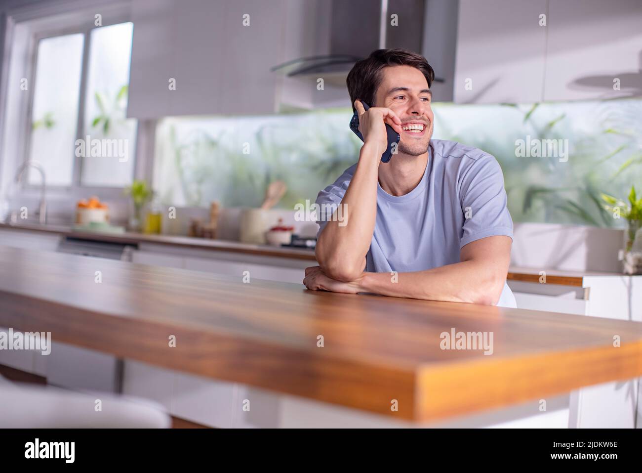 Mid adult man talking on mobile phone at home Stock Photo