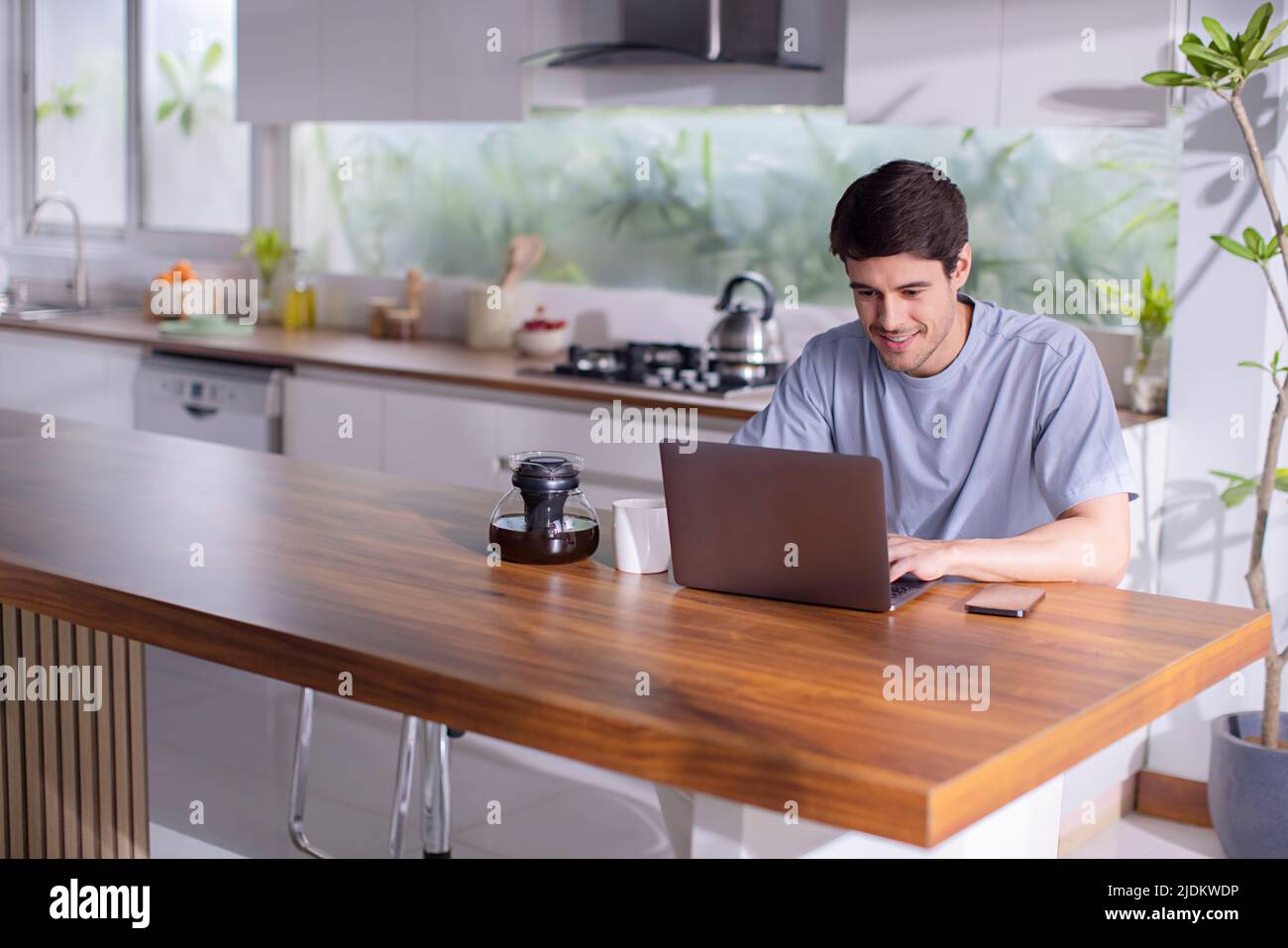 Mid adult man working on laptop at home Stock Photo