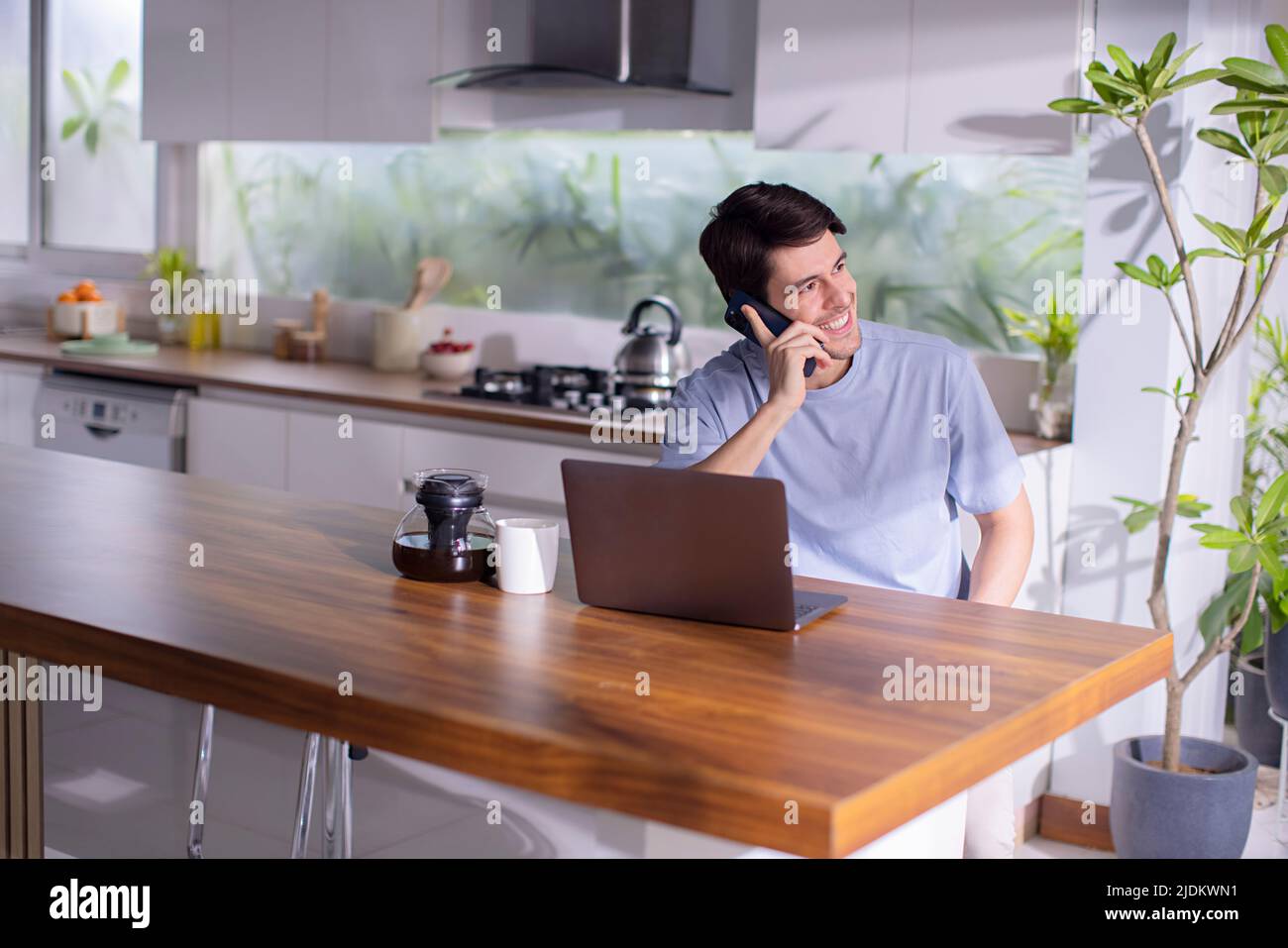 Mid adult man talking on mobile phone at home Stock Photo