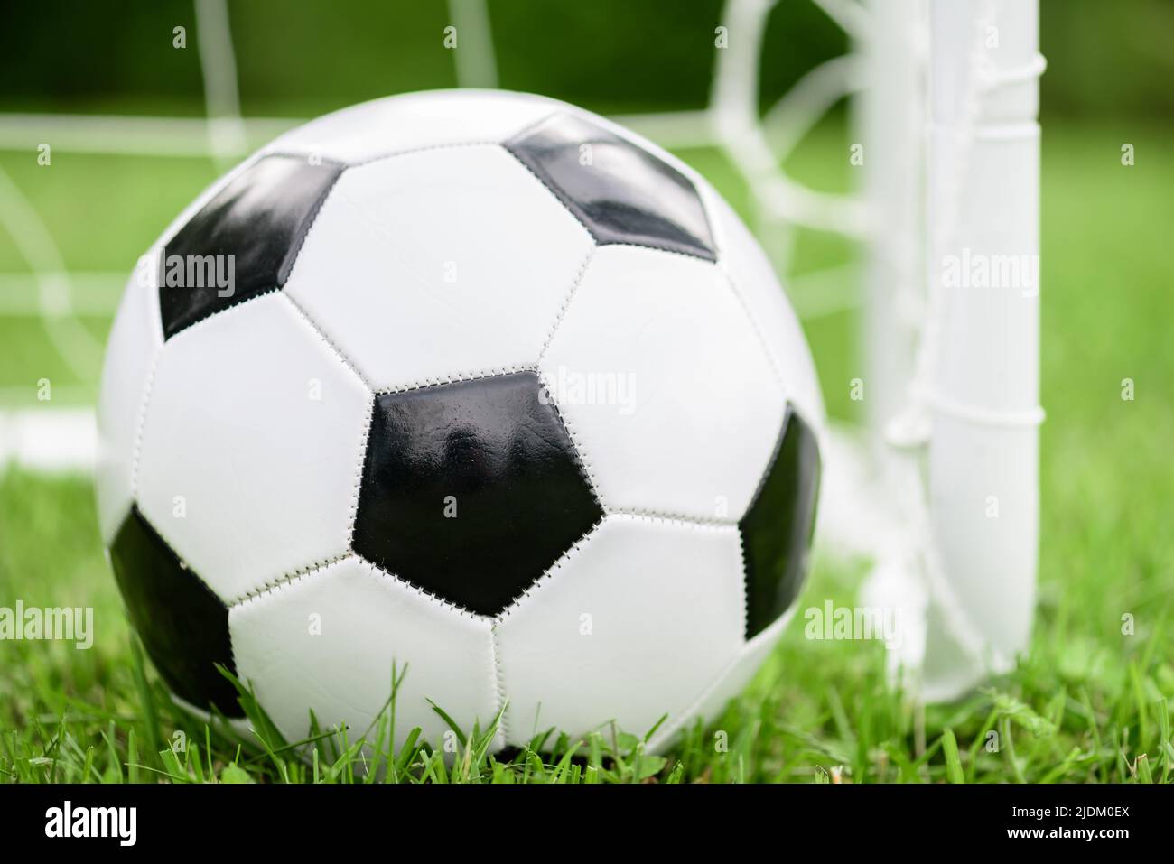 Generic black and white football (soccer) ball next to mini goal Stock Photo