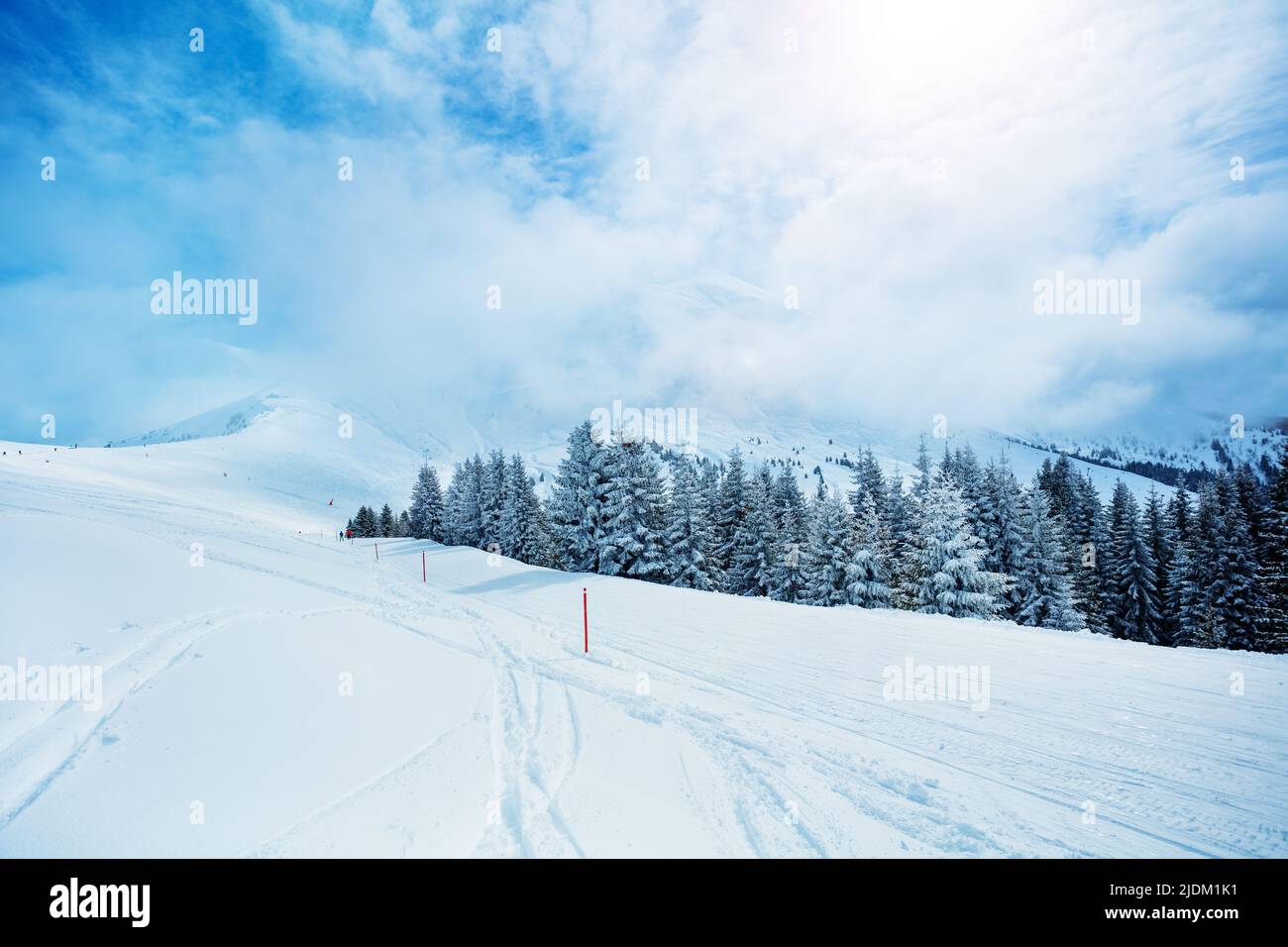 Ski track in the mountain range and valley covered with snow Stock Photo