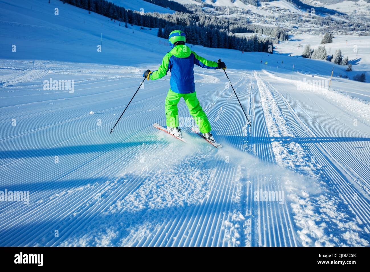Boy ski downhill fast the fresh track view from behind Stock Photo
