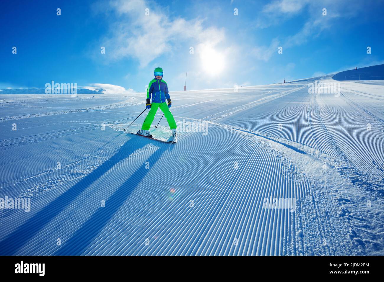 Boy ski downhill fast the fresh track on sunny morning Stock Photo