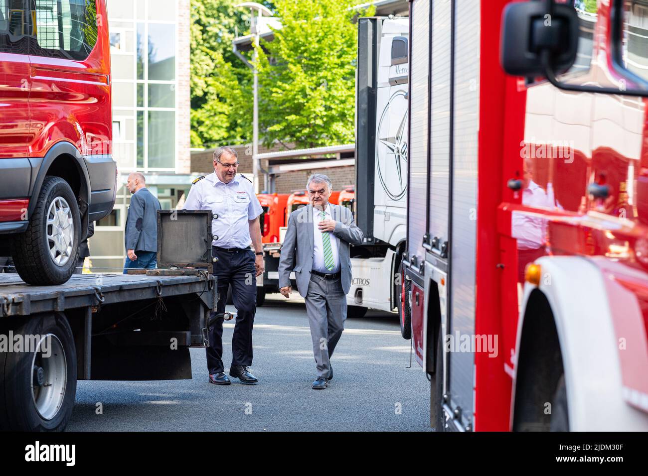 22 June 2022, North Rhine-Westphalia, Münster: Herbert Reul (CDU, r), Minister of the Interior of the State of North Rhine-Westphalia, hands over a total of 15 personnel carriers (MTF) and 1 auxiliary fire fighting group vehicle (HLF) with Berthold Penkert, Director of the Institute of Firefighters NRW (IDF) for transport to Ukraine. The state is donating 15 decommissioned personnel carriers and one fire fighting group vehicle. The oldest vehicle was taken out of service in 2010. The donations are part of the inventory of the Institute of Firefighters (IdF) based in Münster. Photo: Guido Kirch Stock Photo