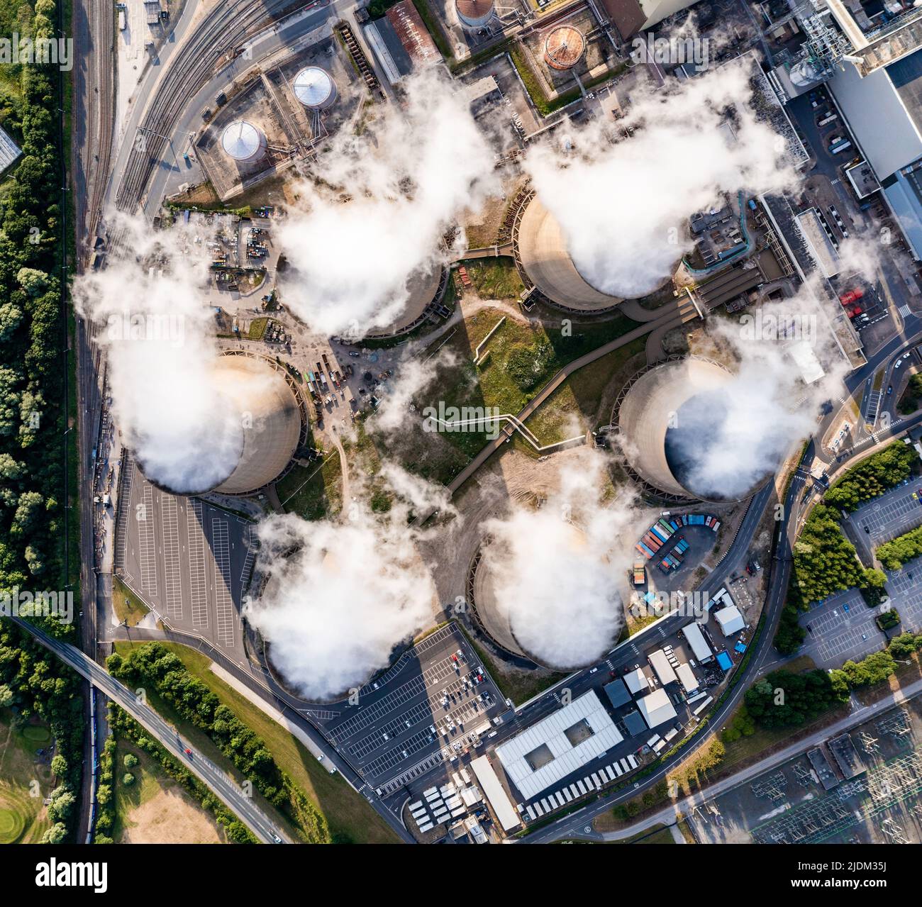 Aerial top down view of a group of cooling towers emitting steam at a large coal fired power station Stock Photo