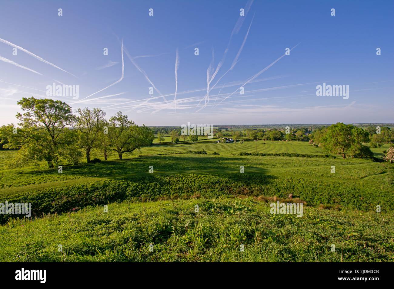 Brinklow village, Warwickshire. View of  farmland from Brinklow Castle looking south. Numerous vapour trails in sky. Stock Photo
