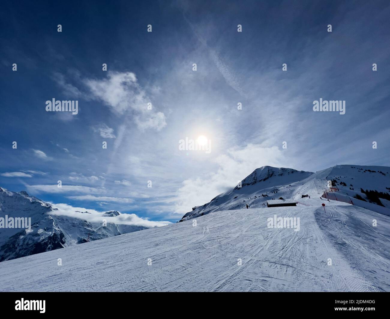 View of alpine ski track and mountain tops high in the Alps Stock Photo