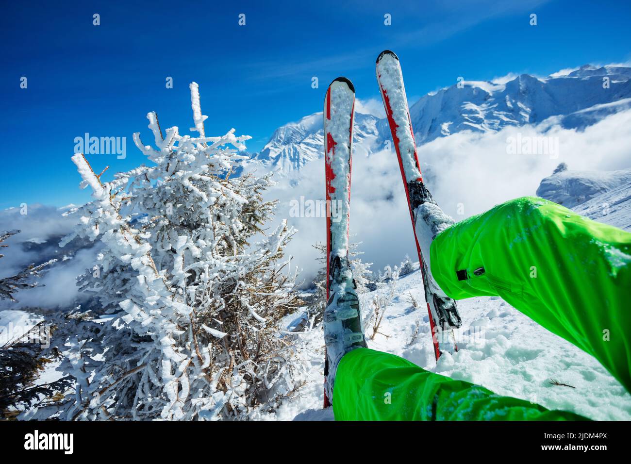 Skier legs and ski close-up over mountain peaks Stock Photo