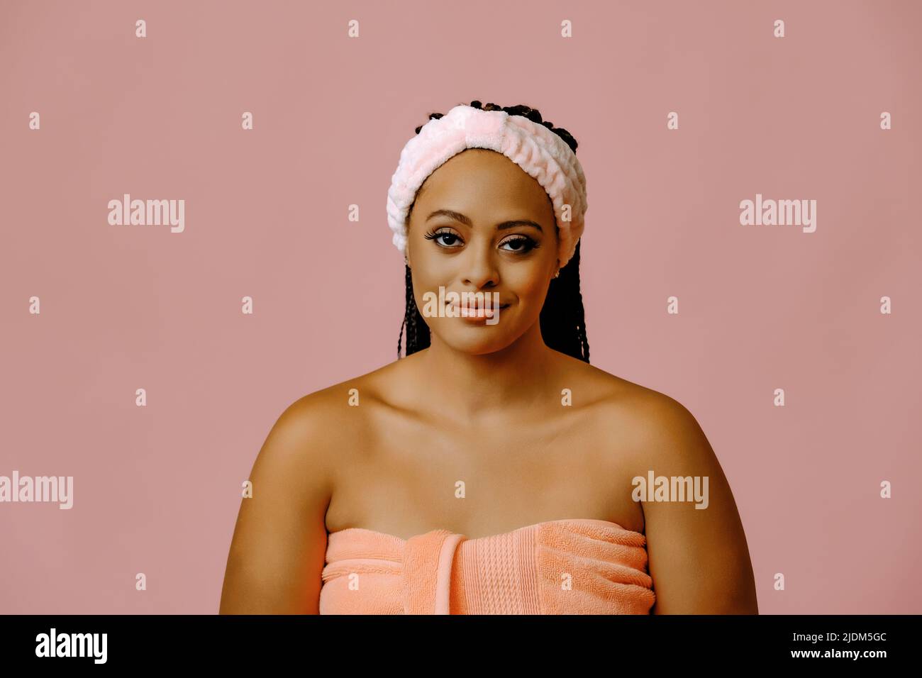 beauty smiling black woman with perfect skin in towel looking at camera studio shot Stock Photo