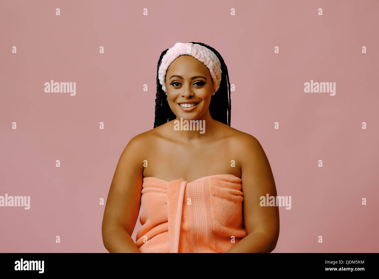 beauty smiling black woman with perfect skin in towel looking at camera studio shot Stock Photo