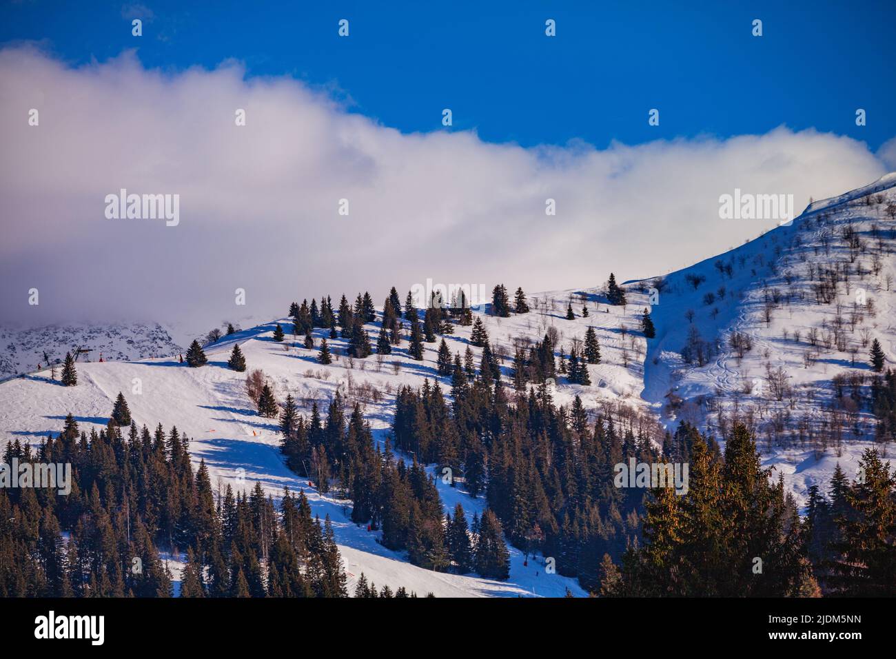 Alpine ski track on the hill covered in snow of Alps mountains Stock Photo