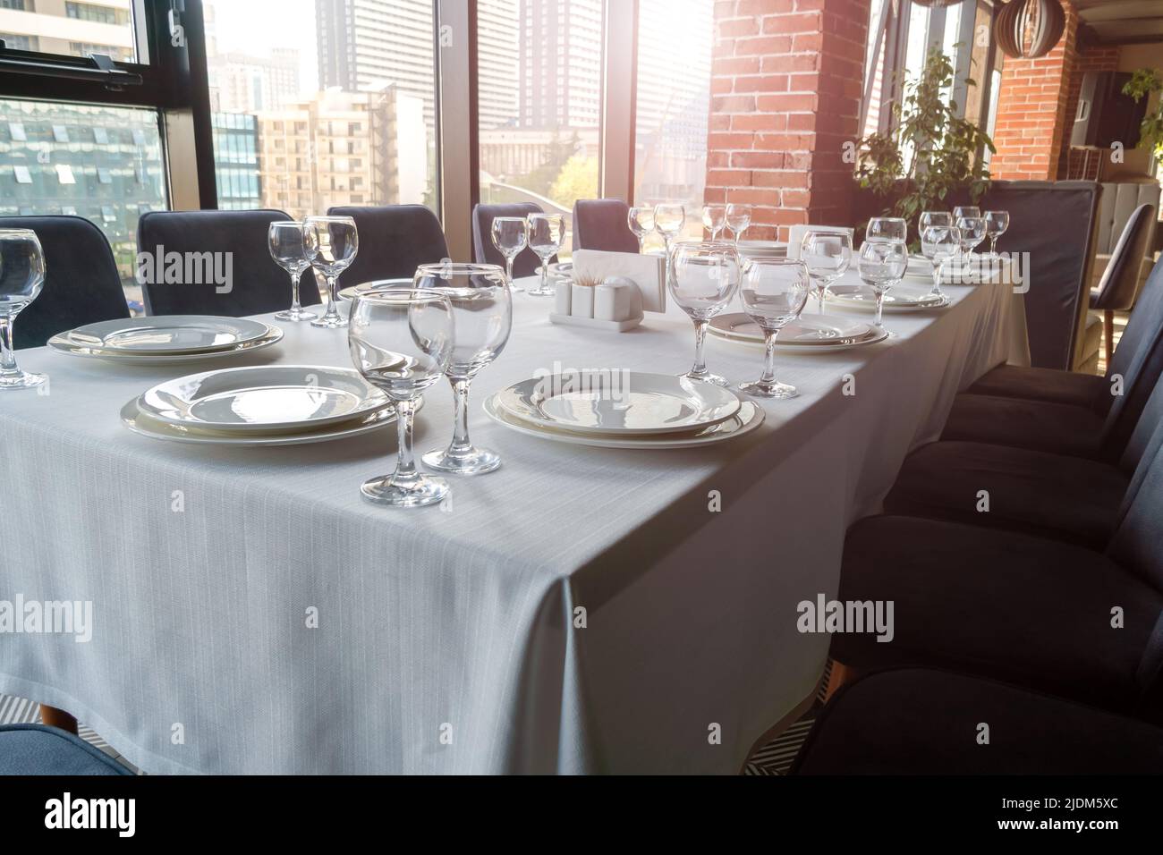 Table set with empty glasses, white plates in a restaurant Stock Photo