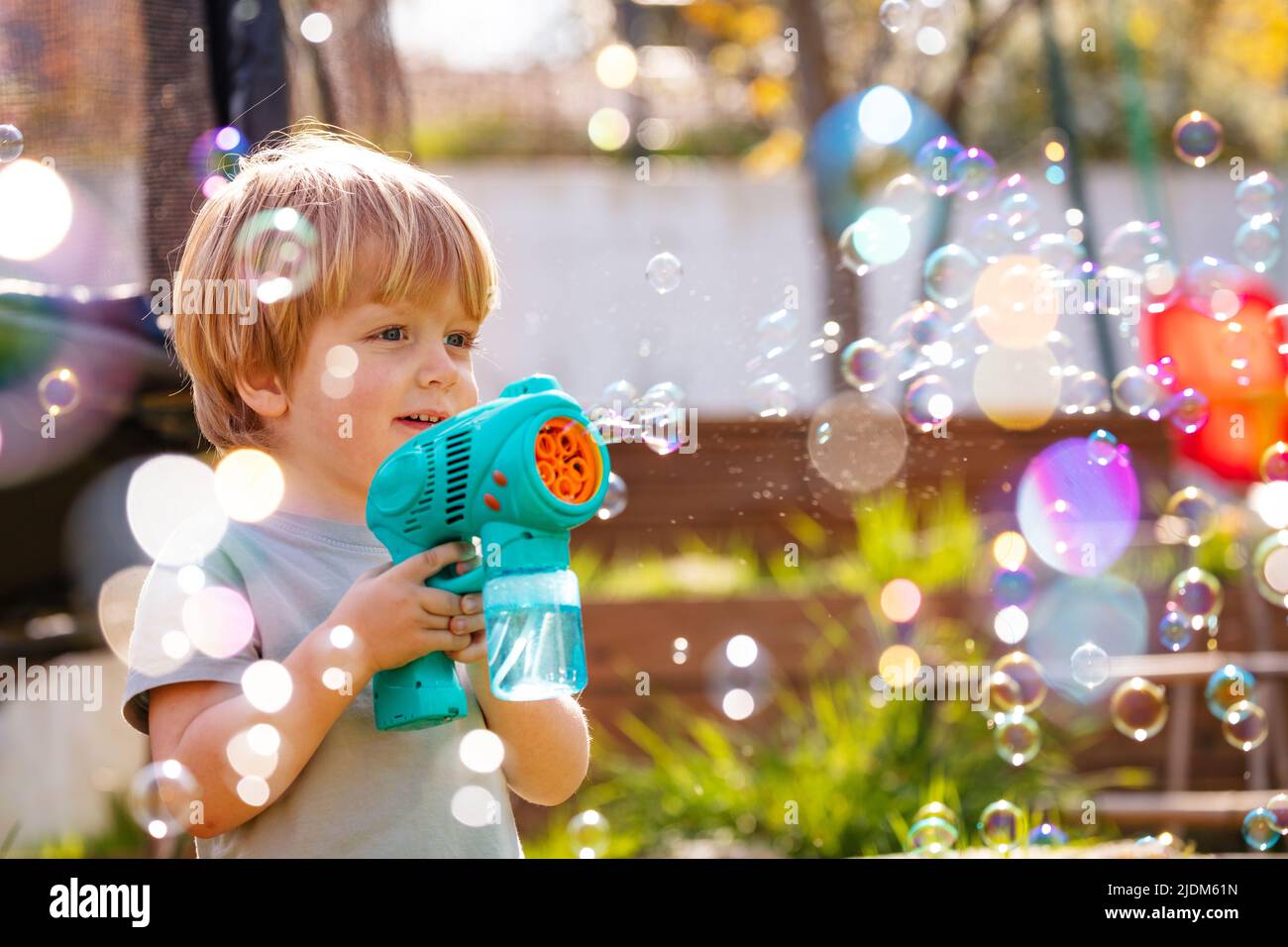 Portrait of a boy play with soap bubbles holding bubble gun Stock Photo