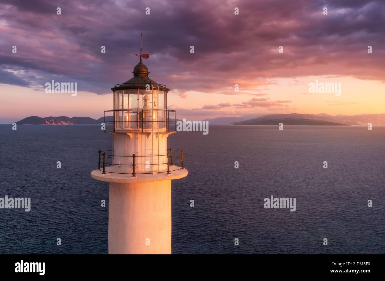 Lighthouse on the mountain peak at colorful sunset in summer Stock Photo