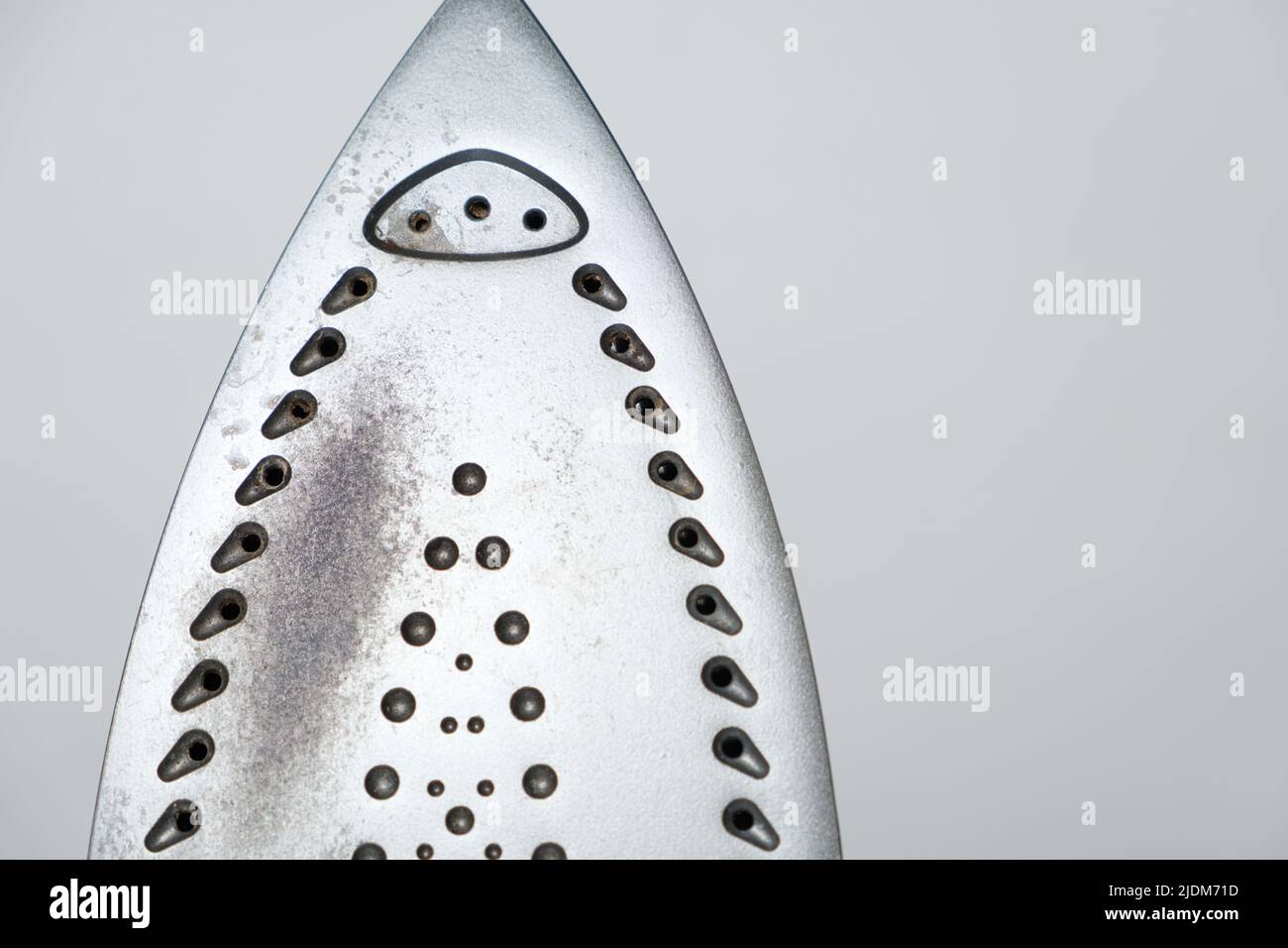 Damaged sole of the iron, brown stains and traces of burning with smoke