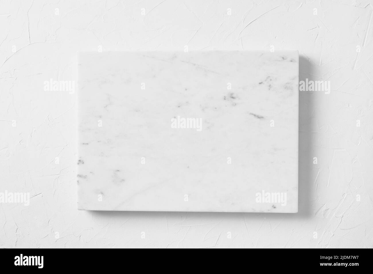 Empty white marble board on light gray stone table. Food and cooking background with free space for text. Cooking concept with copy space. Top view. Stock Photo