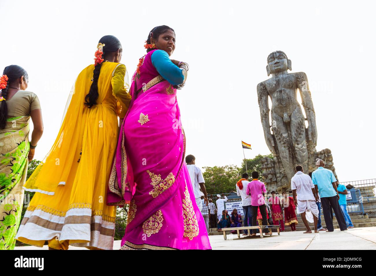 Dharmasthala, Karnataka, India : Women in colourful saris walk towards the  12 m high monolithic statue of Bahubali (Gomateshwara) at Ratnagiri Hill. Stock Photo