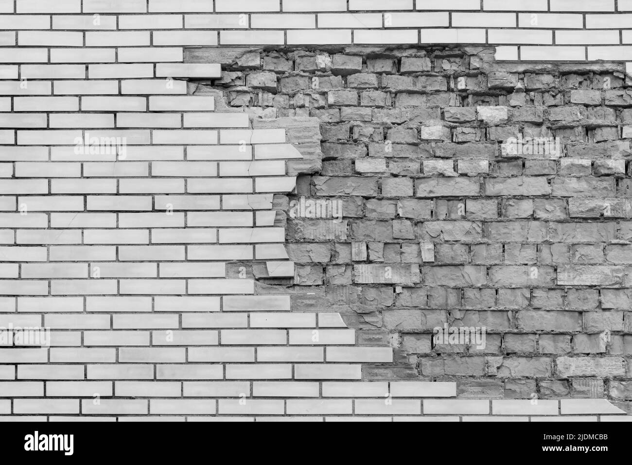 Brick grey broken masonry wall with cement white concrete damaged facade background texture old. Stock Photo