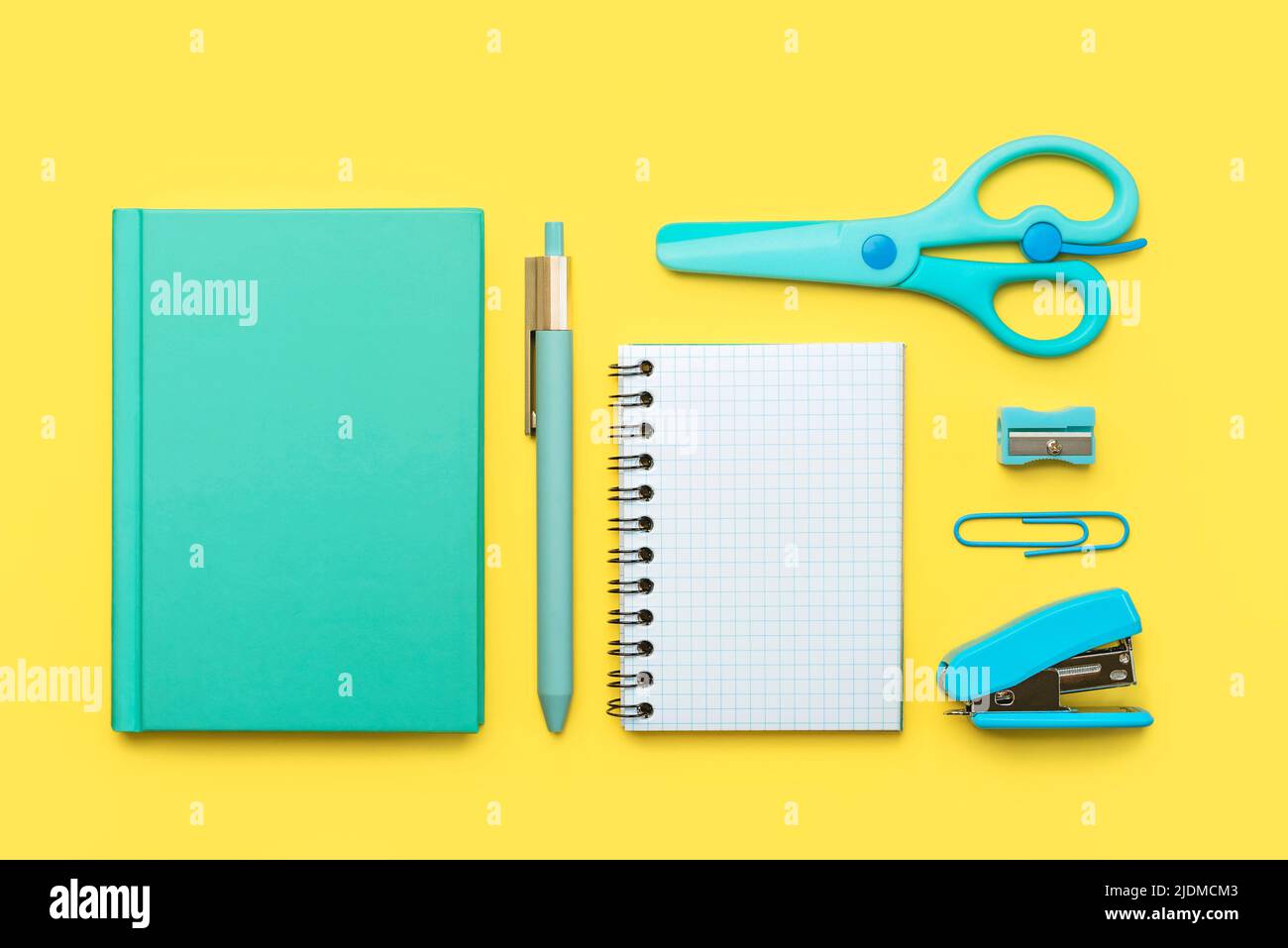 Top view of notepad, school supplies and spiral notepad with space for text on yellow background. Back to school concept Stock Photo