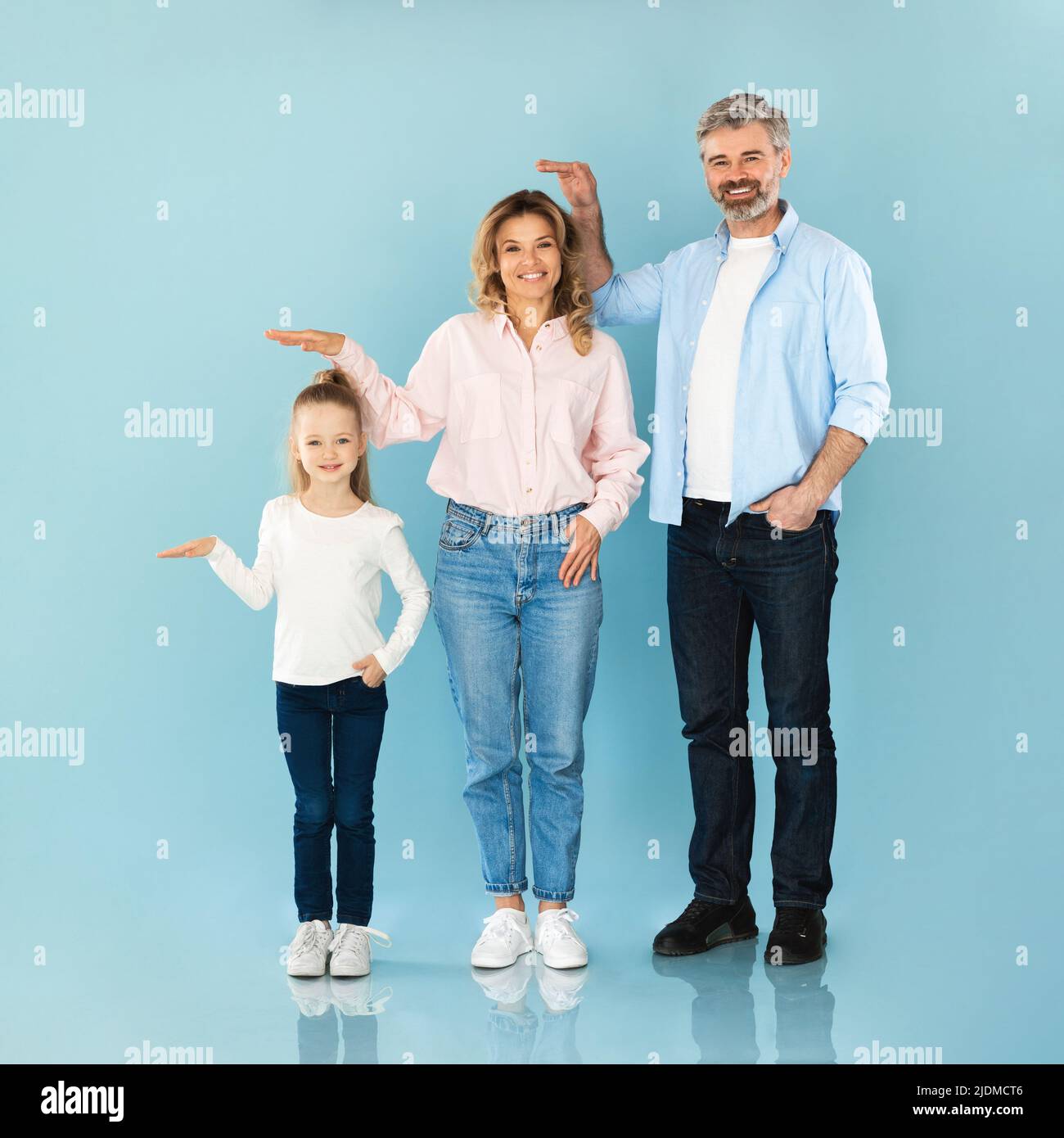 Square Shot Of Family Showing Comparing Their Heights, Blue Background ...