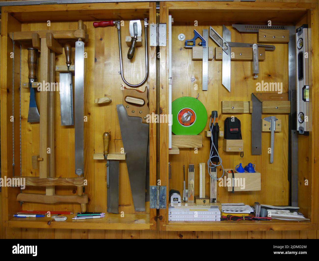 Wooden tool cabinet filled with technician equipment in home workshop. Stock Photo