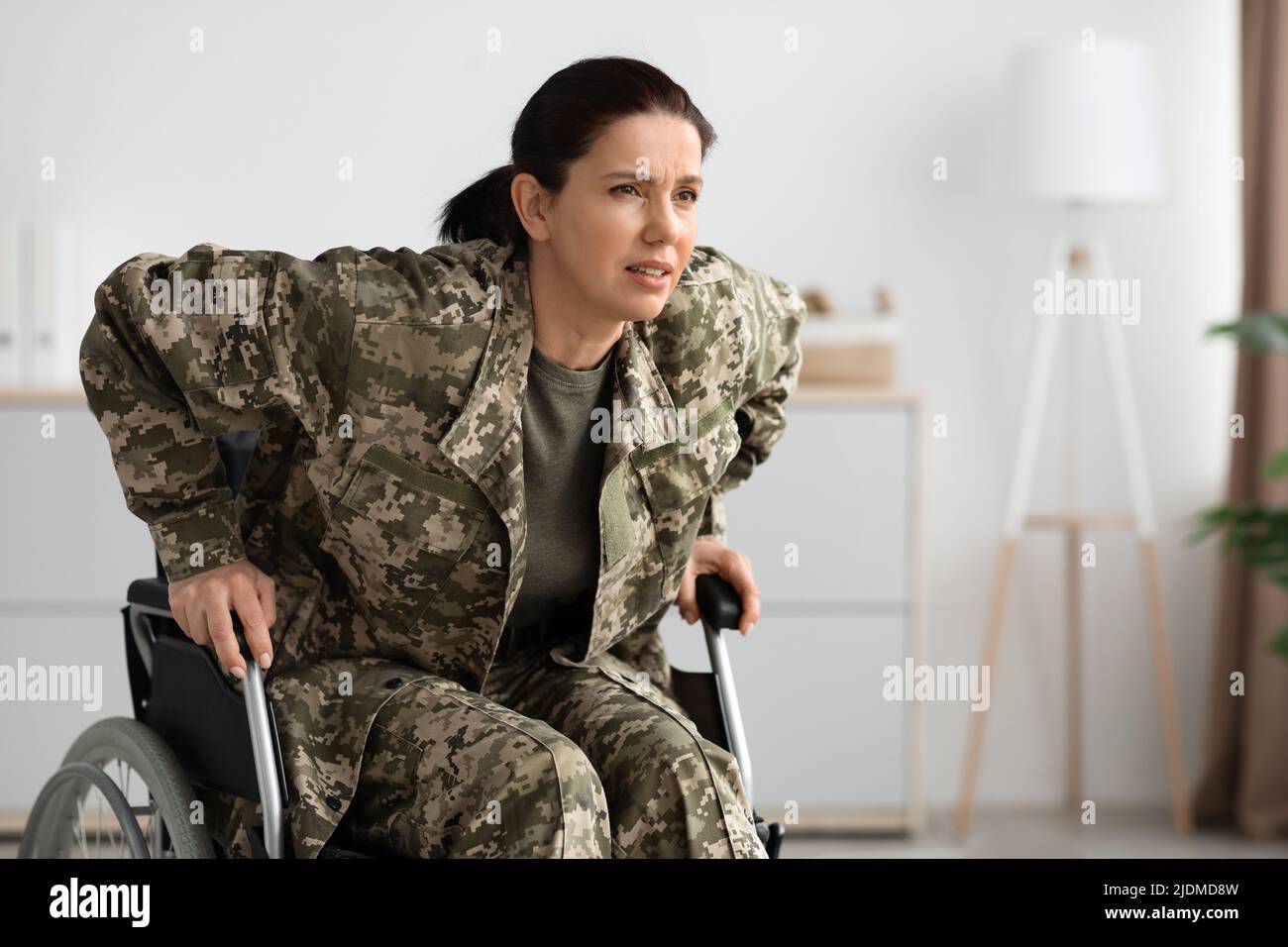 Paraplegics Concept. Soldier Woman Trying To Get Up From Wheelchair At