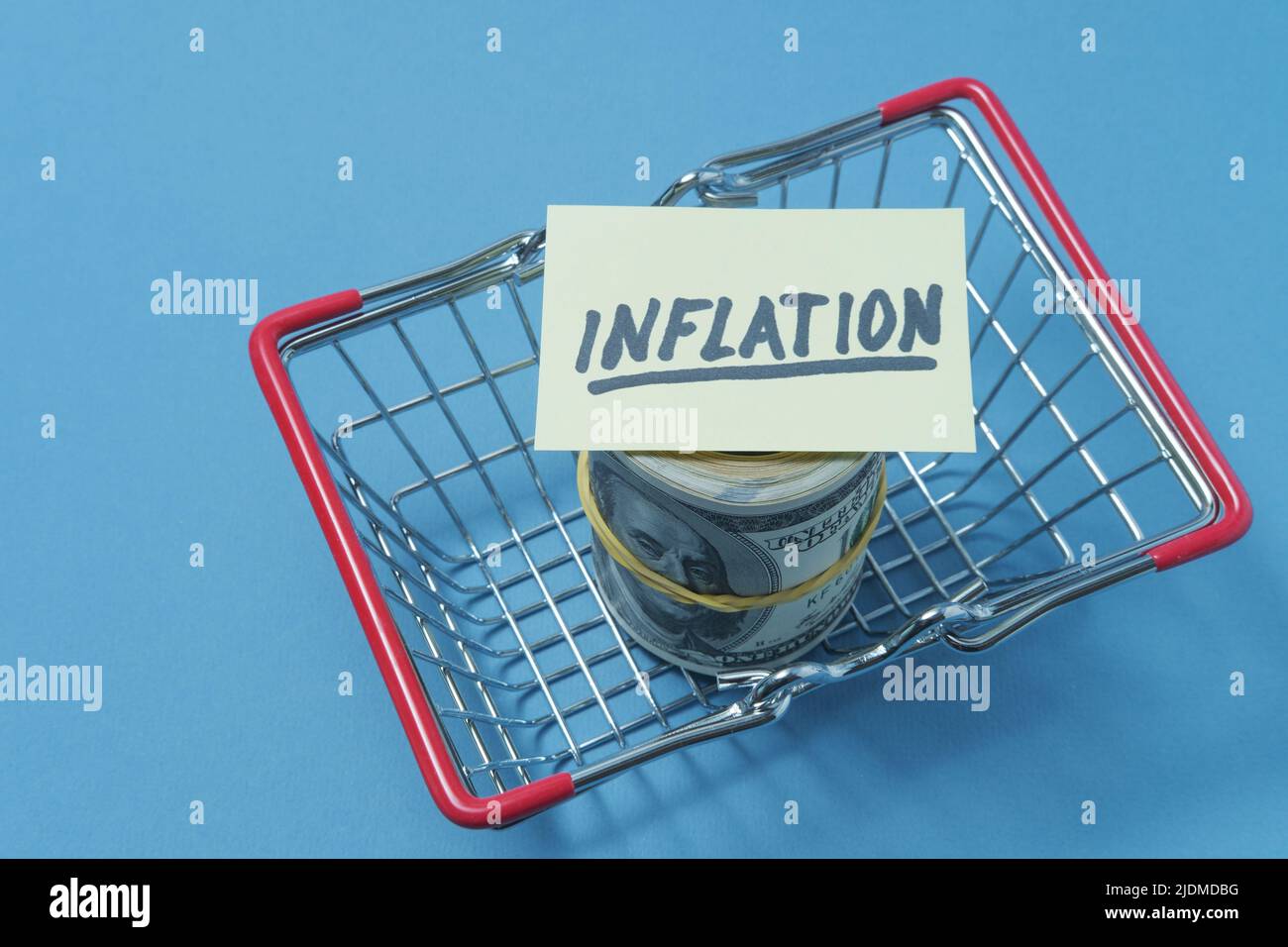 Dollars are in a grocery basket, with a poster on which the inscription inflation Stock Photo