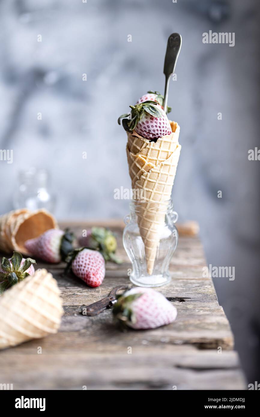 Frozen strawberries in wafers .Sweet fruit . Low fat ice cream .Wooden table .Healthy food and drink Stock Photo