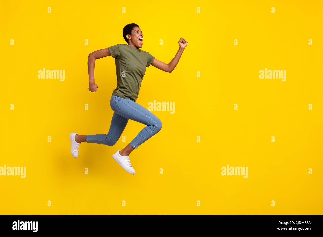 Full body portrait of crazy excited person look empty space jump rush isolated on yellow color background Stock Photo