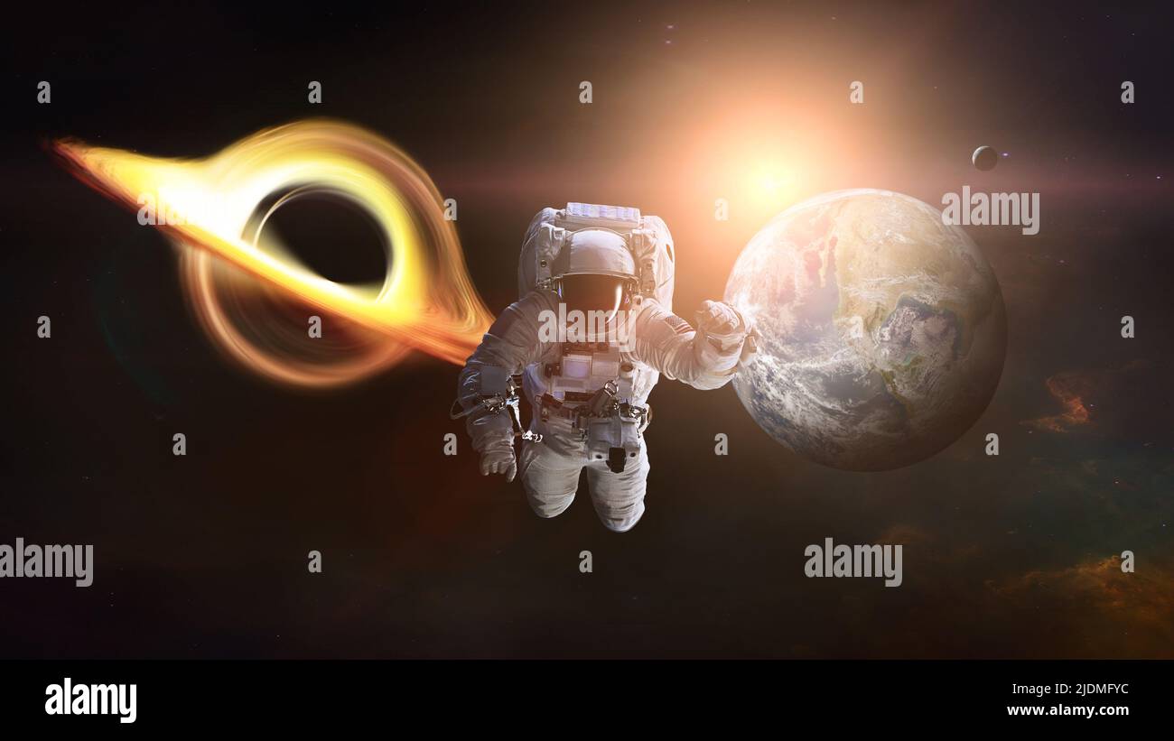 Spaceman in outer space with black hole and Earth planet. Elements of this image furnished by NASA. Stock Photo
